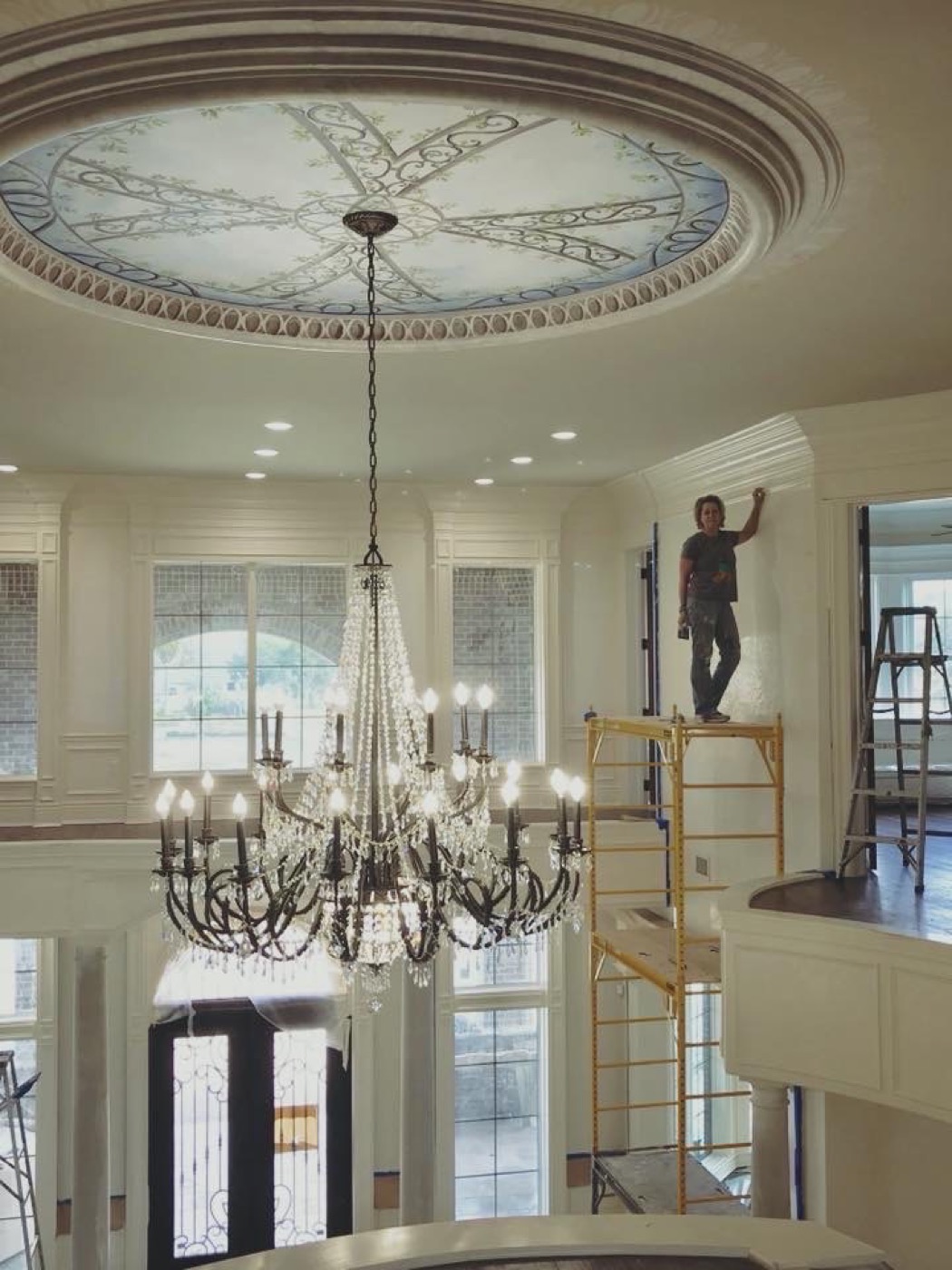 Connie Harris painting a ceiling mural on scaffolding